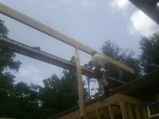 Carpenter setting a ridge beam over a new addition frame — Ice Dam Removal by Roofing Brothers in Lemont
