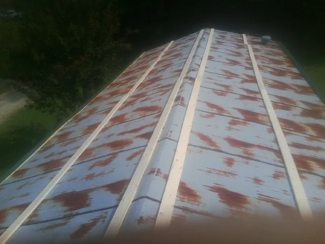 Rusted metal roof panels with new wood purlins before replacement — Storm Damage Roof Repair in Lemont by Roofing Brothers