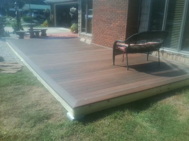 New wood deck and wicker chair beside a brick house in Lemont
