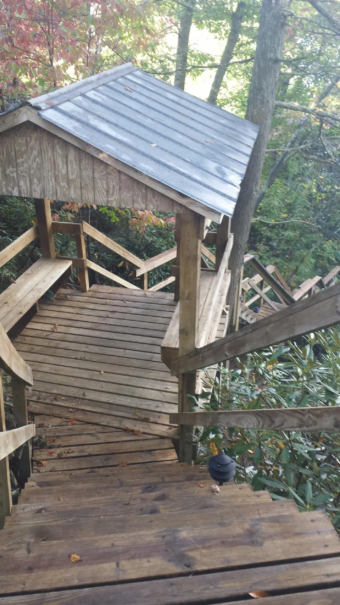 Metal roofed shelter over wooden steps on a wooded walkway — Skylight Repair & Installation work by our crew in Lemont