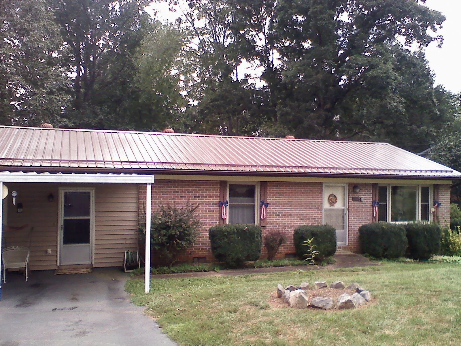 Bronze metal roof and carport on a brick ranch home — Roof Repair work by our crew in Lemont
